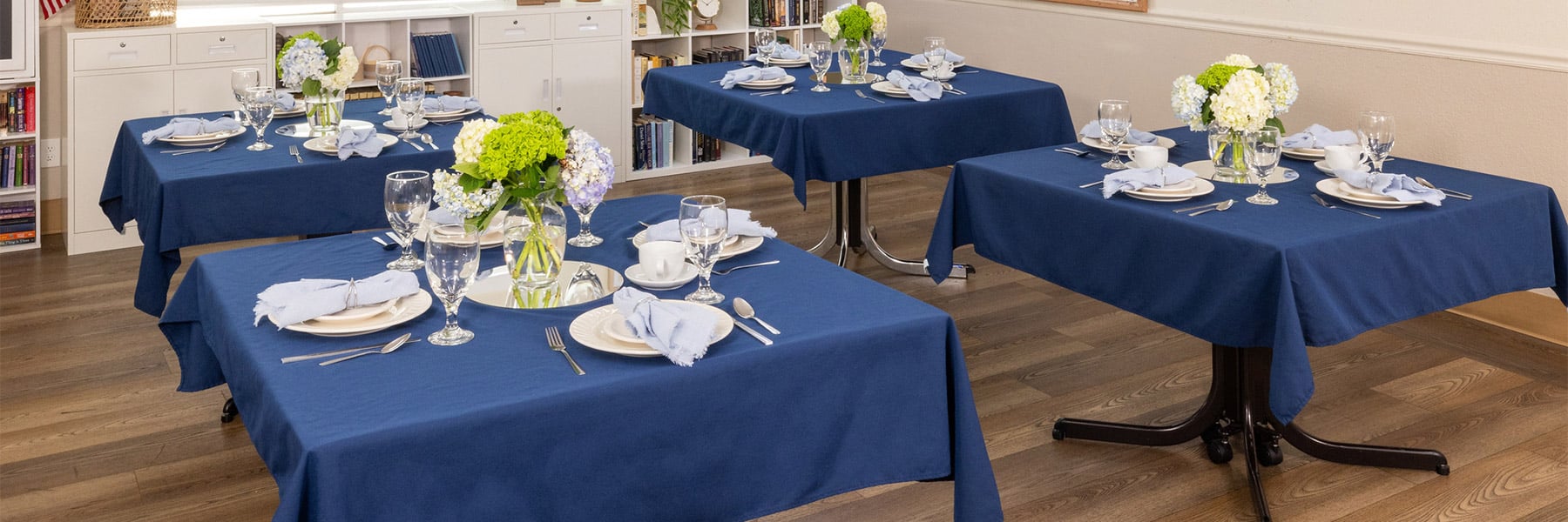 Dining room tables at Rock Creek Care Center with flowers and plates set
