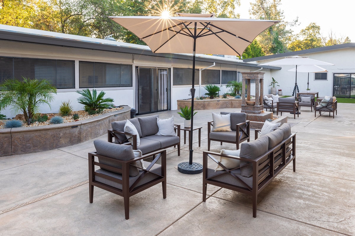 Back patio with couches and fountain at Rock Creek Care Center